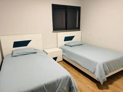 a bedroom with two beds and a window at Paradise Garajau in Garajau