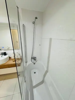 a white bathroom with a shower and a sink at Paradise Garajau in Garajau