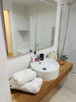 a bathroom with a sink and a mirror and towels at Paradise Garajau in Garajau