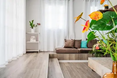 a living room with white curtains and a couch at Sweet Home Madeira in Camacha