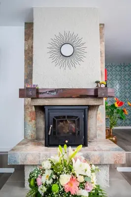 a fireplace with a flower arrangement in front of it at Sweet Home Madeira in Camacha