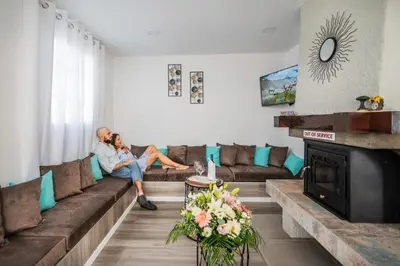 a man sitting on a couch in a living room at Sweet Home Madeira in Camacha