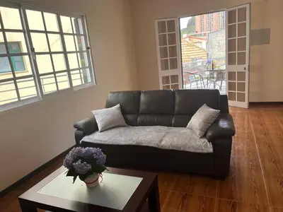 a living room with a black couch and a table at Vivenda da Praia in Machico