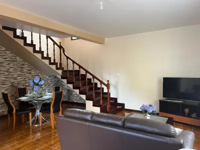 a living room with a couch and a television and a table at Vivenda da Praia in Machico
