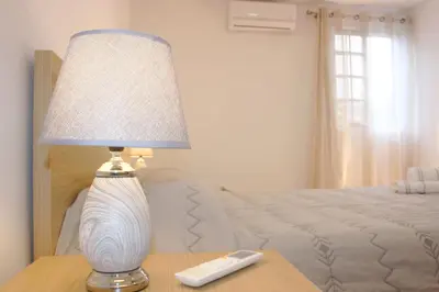a lamp sitting on a table next to a bed at Lugar dos Louros 2 in Estreito da Calheta