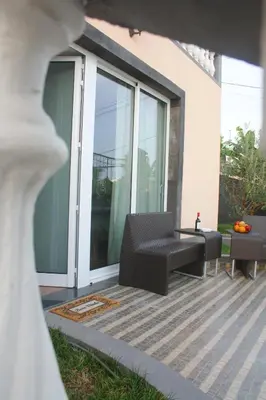 a patio with a couch and a table and chairs at Lugar dos Louros 2 in Estreito da Calheta