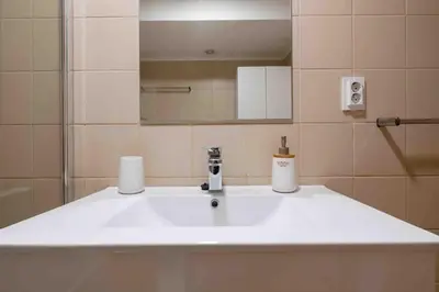 a bathroom with a white sink and a mirror at By the Sea III Lido - com piscina in Funchal
