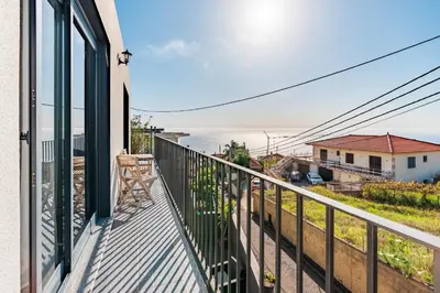 a balcony with a view of a street and buildings at Casa Yeni modern two bedrooms in Arco da Calheta
