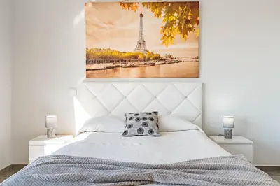 a white bedroom with a bed and a painting on the wall at Casa Yeni modern two bedrooms in Arco da Calheta