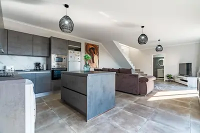 a kitchen and living room with a couch and a table at Casa Yeni modern two bedrooms in Arco da Calheta