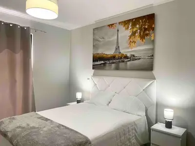 a bedroom with a bed and a picture of the eiffel tower at Casa Yeni modern two bedrooms in Arco da Calheta