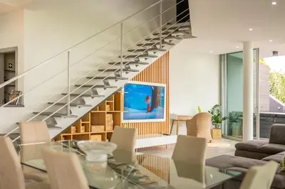 a living room with a glass table and a staircase at Villa 65 - City Edge Retreat in Funchal
