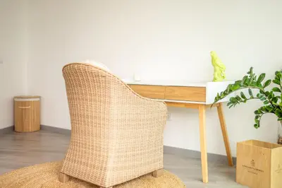a wicker chair in front of a wooden desk at Villa 65 - City Edge Retreat in Funchal
