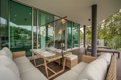 a living room with glass walls and a table at Villa 65 - City Edge Retreat in Funchal
