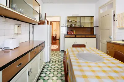 a small kitchen with a table and a sink at Casal Do Farrobo in Funchal