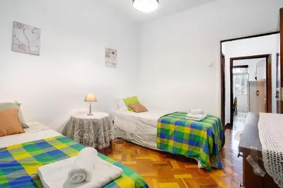 a room with two beds and a table with a lamp at Casal Do Farrobo in Funchal