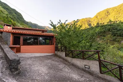 a house with a red garage with a mountain at Villa Fontes 5 in Ponta Delgada