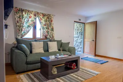 a living room with a green couch and a table at Villa Fontes 7 in Ponta Delgada