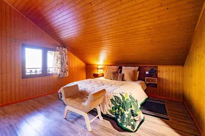 a bedroom with a bed and a chair and a window at Villa Fontes 7 in Ponta Delgada