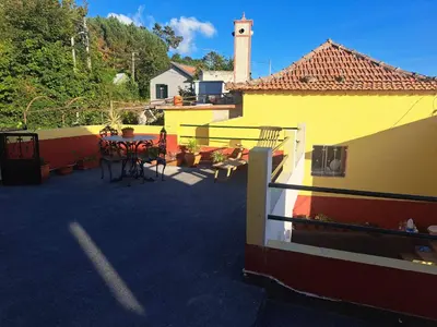 a patio with a table and chairs and a building at Calheta Countryside in Calheta