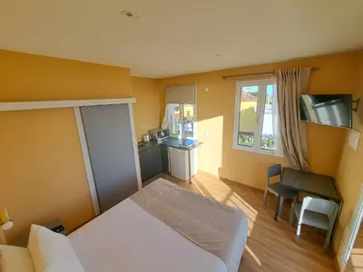 a room with a bed and a desk and a kitchen at Calheta Countryside in Calheta