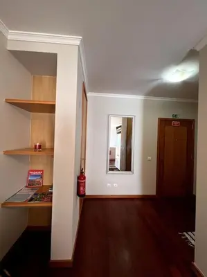 an empty room with a hallway with a door and a shelf at By the Sea - Apartamento acolhedor e relaxante. in Caniço