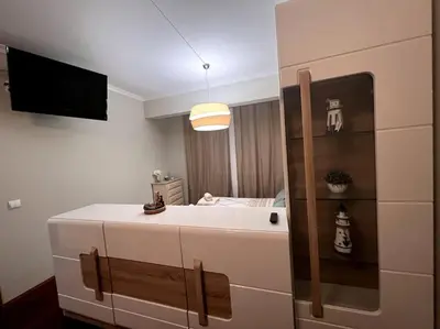 a bathroom with a sink and a tv in a room at By the Sea - Apartamento acolhedor e relaxante. in Caniço