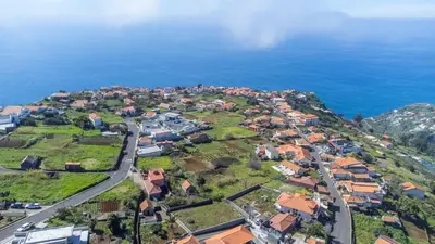 an aerial view of a village next to the ocean at The Red Nest by GALMI in Arco da Calheta