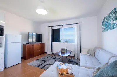 a living room with a couch and a refrigerator at The Red Nest by GALMI in Arco da Calheta