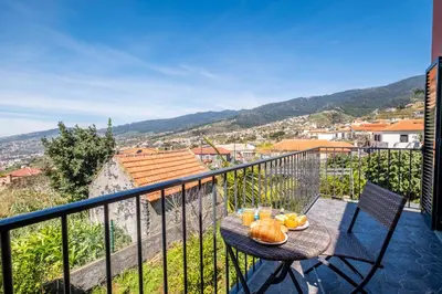 a table with a bowl of fruit on a balcony at The Red Nest by GALMI in Arco da Calheta