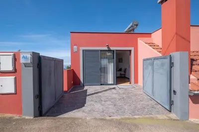 a red building with a door in front of it at The Red Nest by GALMI in Arco da Calheta