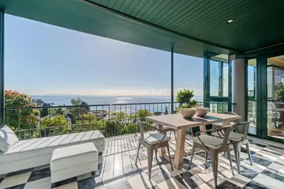 a balcony with a table and chairs and a view of the ocean at Luxury Oceanfront at Reid's Gardens in Funchal