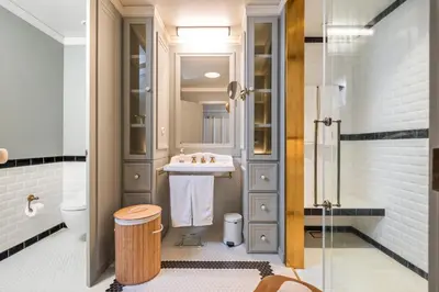 a bathroom with a shower with a stool in it at Luxury Oceanfront at Reid's Gardens in Funchal