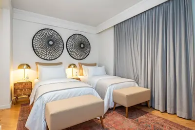 two beds in a hotel room with white walls at Luxury Oceanfront at Reid's Gardens in Funchal
