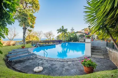 a swimming pool in a yard with stairs and plants at Luxury Oceanfront at Reid's Gardens in Funchal