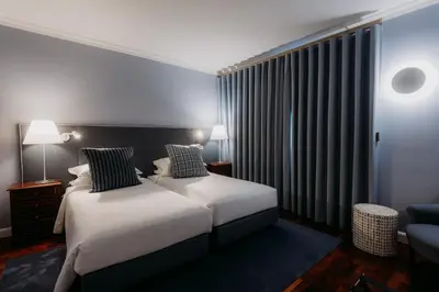 a hotel room with a bed and a chair at Quinta São Gonçalo in Funchal