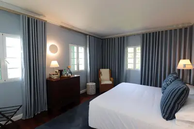 a bedroom with a large white bed and windows at Quinta São Gonçalo in Funchal