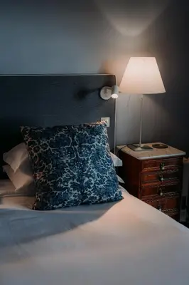 a bed with a pillow and a lamp on a night stand at Quinta São Gonçalo in Funchal