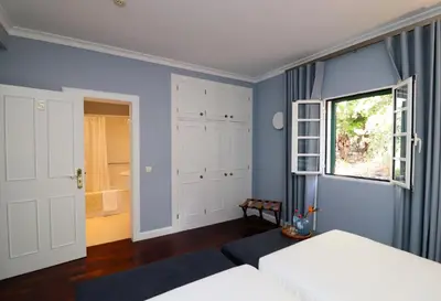 a bedroom with blue walls and a bed and a window at Quinta São Gonçalo in Funchal
