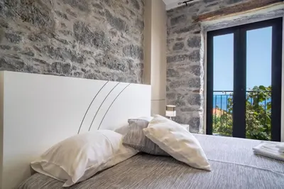 a bedroom with a bed with a stone wall at Madeirense Villa in Santa Cruz in Santa Cruz