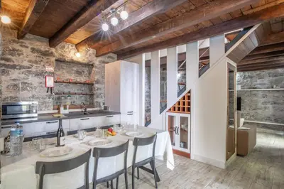a kitchen with a table with chairs and a sink at Madeirense Villa in Santa Cruz in Santa Cruz