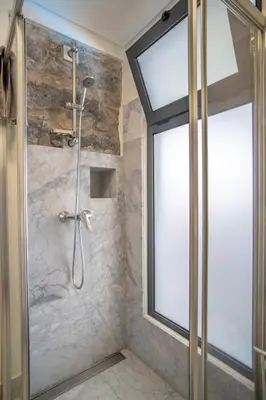 a bathroom with a shower with a glass door at Madeirense Villa in Santa Cruz in Santa Cruz