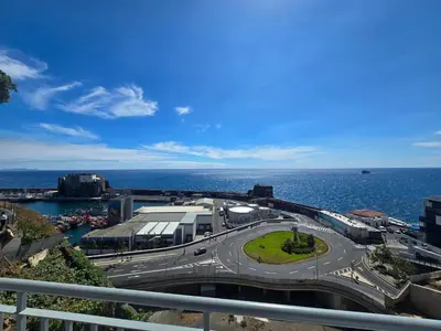 a city street with a bus on a road next to the ocean at Ocean Pearl Apartment Y in Funchal