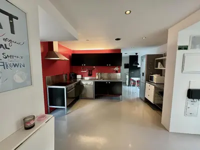 a large kitchen with red walls and stainless steel appliances at Sea Breeze Boutique House in Porto da Cruz
