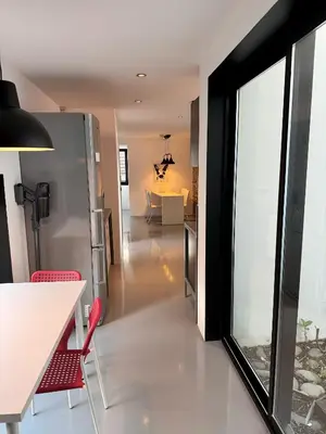 a kitchen and dining room with a table and red chairs at Sea Breeze Boutique House in Porto da Cruz