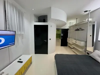 a bedroom with a bed and a tv on a wall at Sea Breeze Boutique House in Porto da Cruz