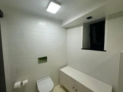 a white bathroom with a toilet and a window at Sea Breeze Boutique House in Porto da Cruz