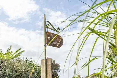 a sign on a pole in front of some plants at Vila Gama Apartaments in Machico