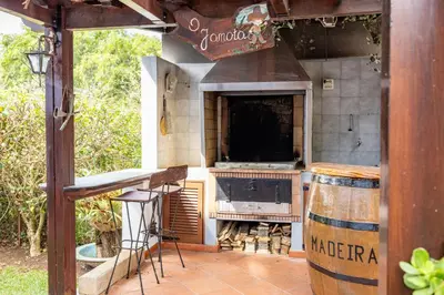 an outdoor kitchen with a stove and a barrel at Vila Gama Apartaments in Machico