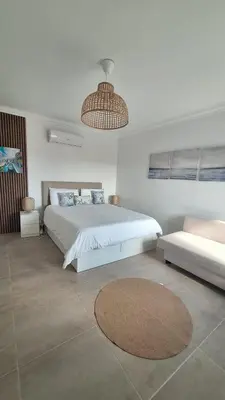 a white bedroom with a large bed and a couch at Bella Sunset Holidays - 3 min da Praia da Mareta in Sagres